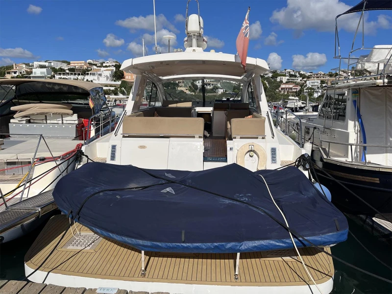 2012 Sealine SC47 yacht docked at marina under blue sky.