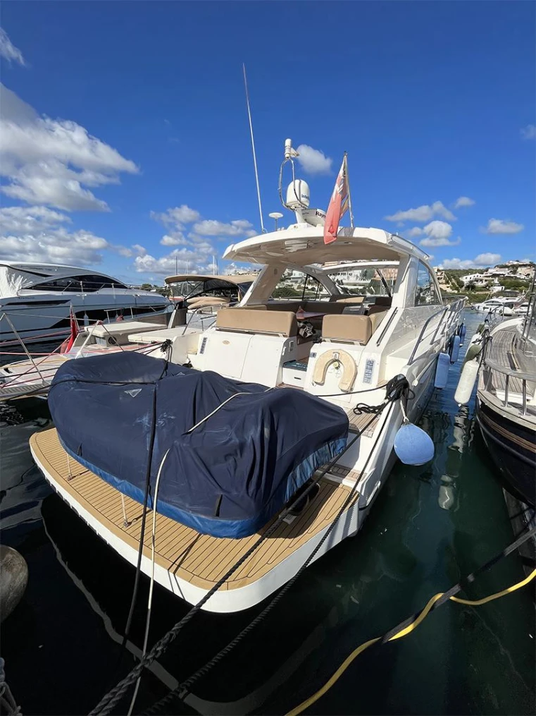 2012 Sealine SC47 yacht docked in marina under clear blue sky.