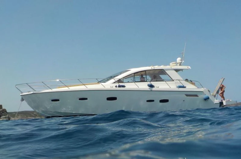 2012 Sealine SC47 yacht cruising on open water under clear blue skies.