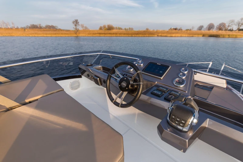 Helm of 2025 Galeon 360 Fly yacht on calm water.