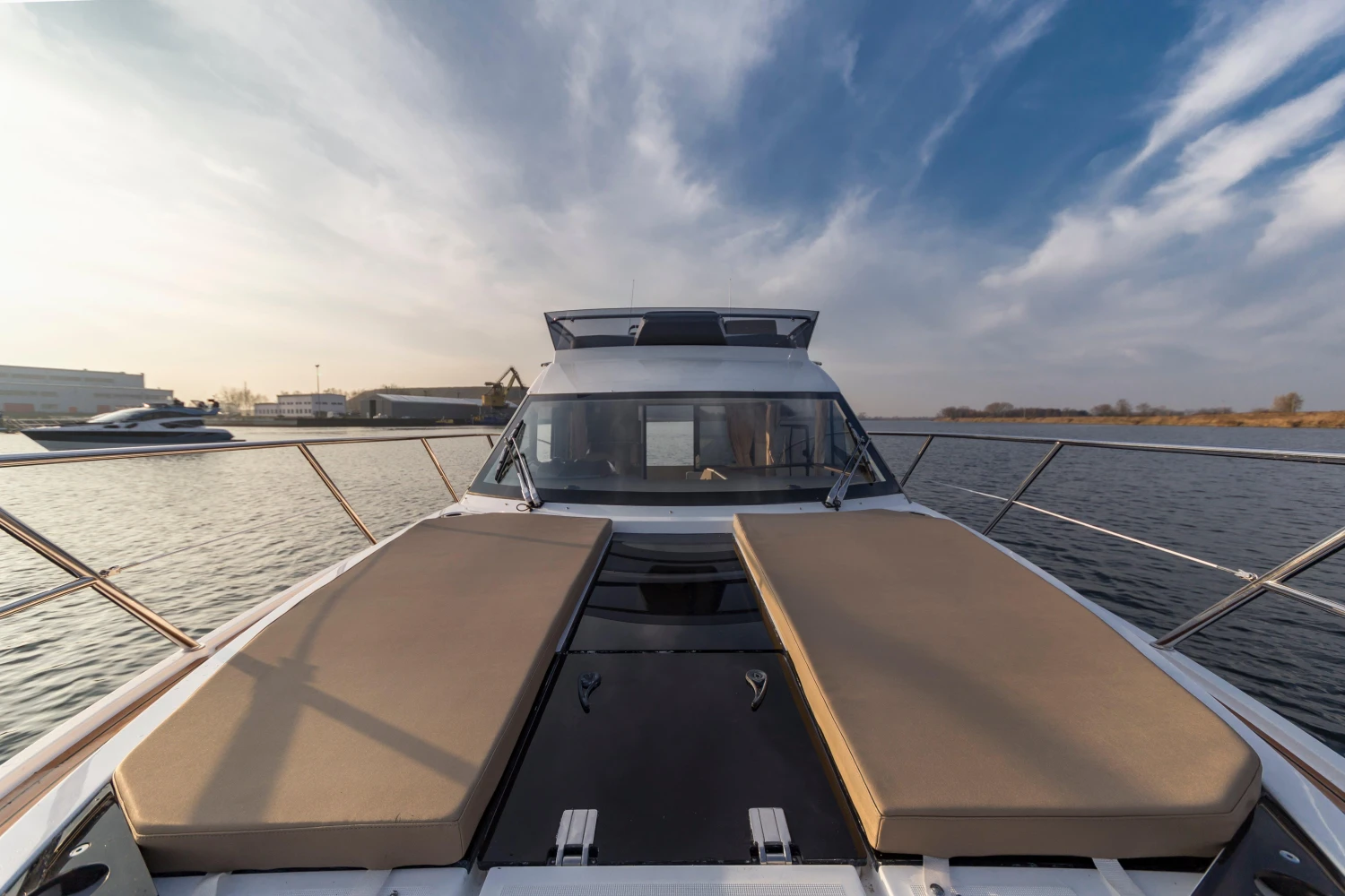 2025 Galeon 360 Fly yacht with sunbeds on deck, cruising on calm waters.