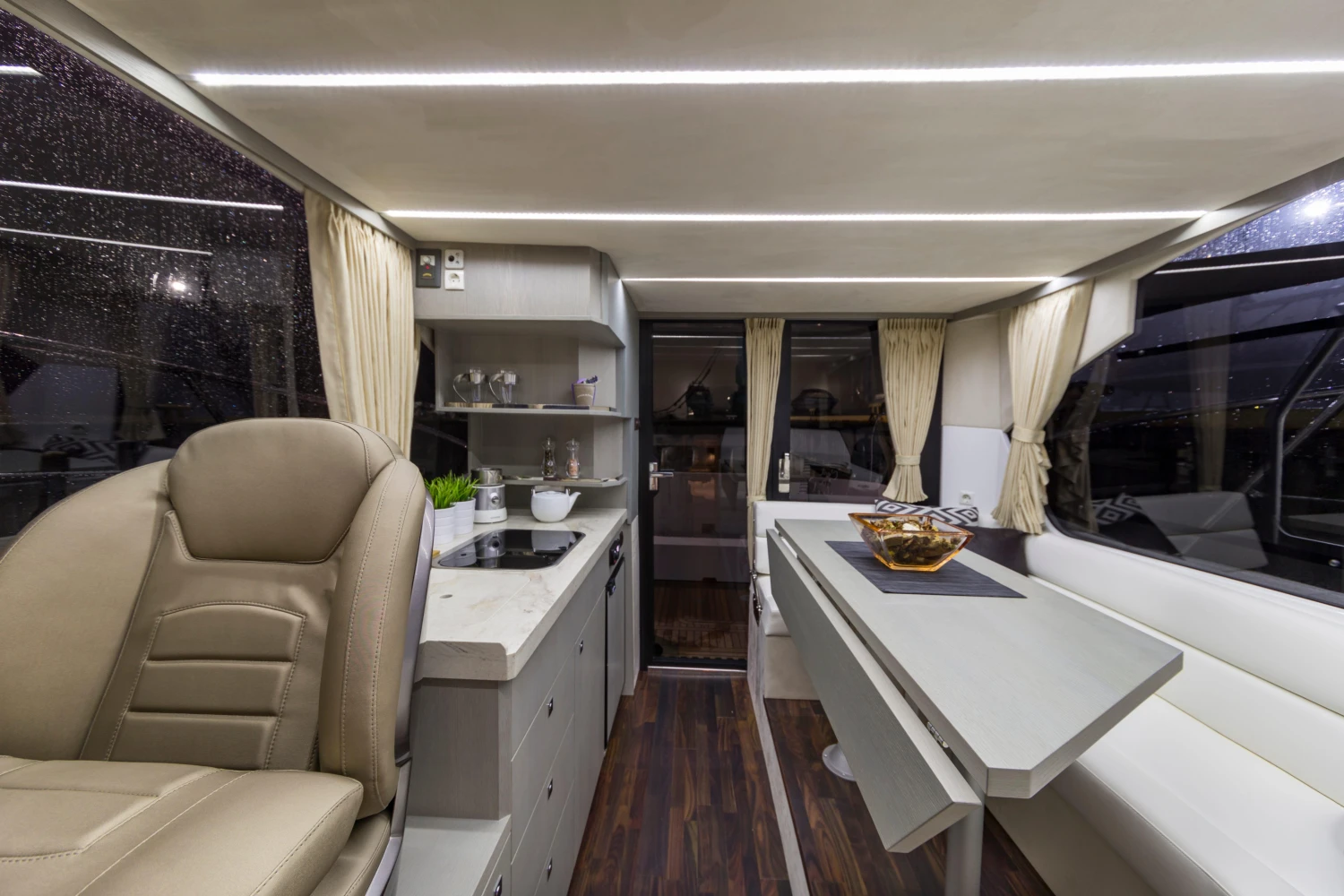 Luxurious interior of 2025 Galeon 360 Fly yacht with modern seating and dining area.