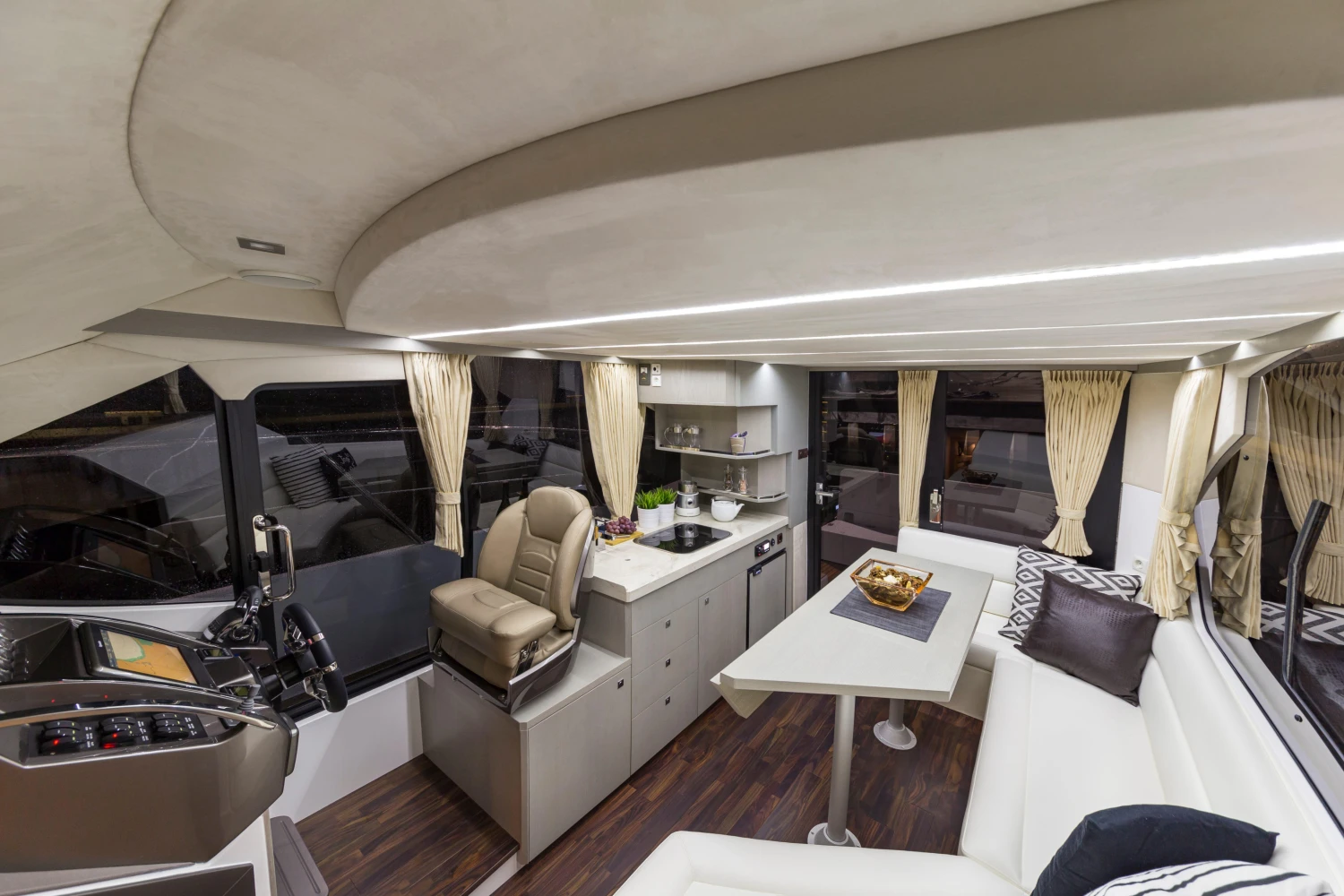 Luxurious interior of 2025 Galeon 360 Fly yacht with modern seating and kitchen area.