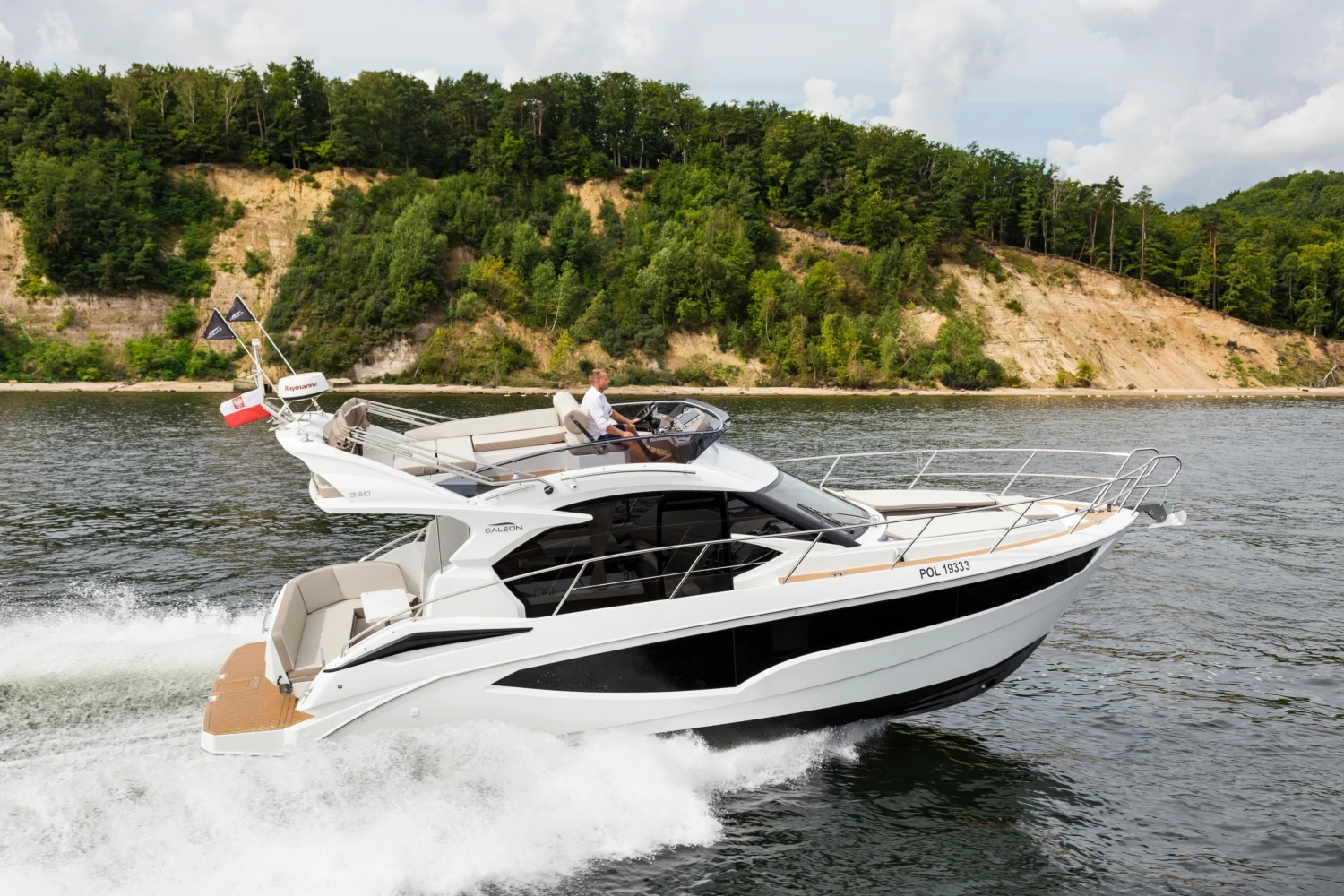 2025 Galeon 360 Fly yacht cruising on a scenic river with lush green hills.