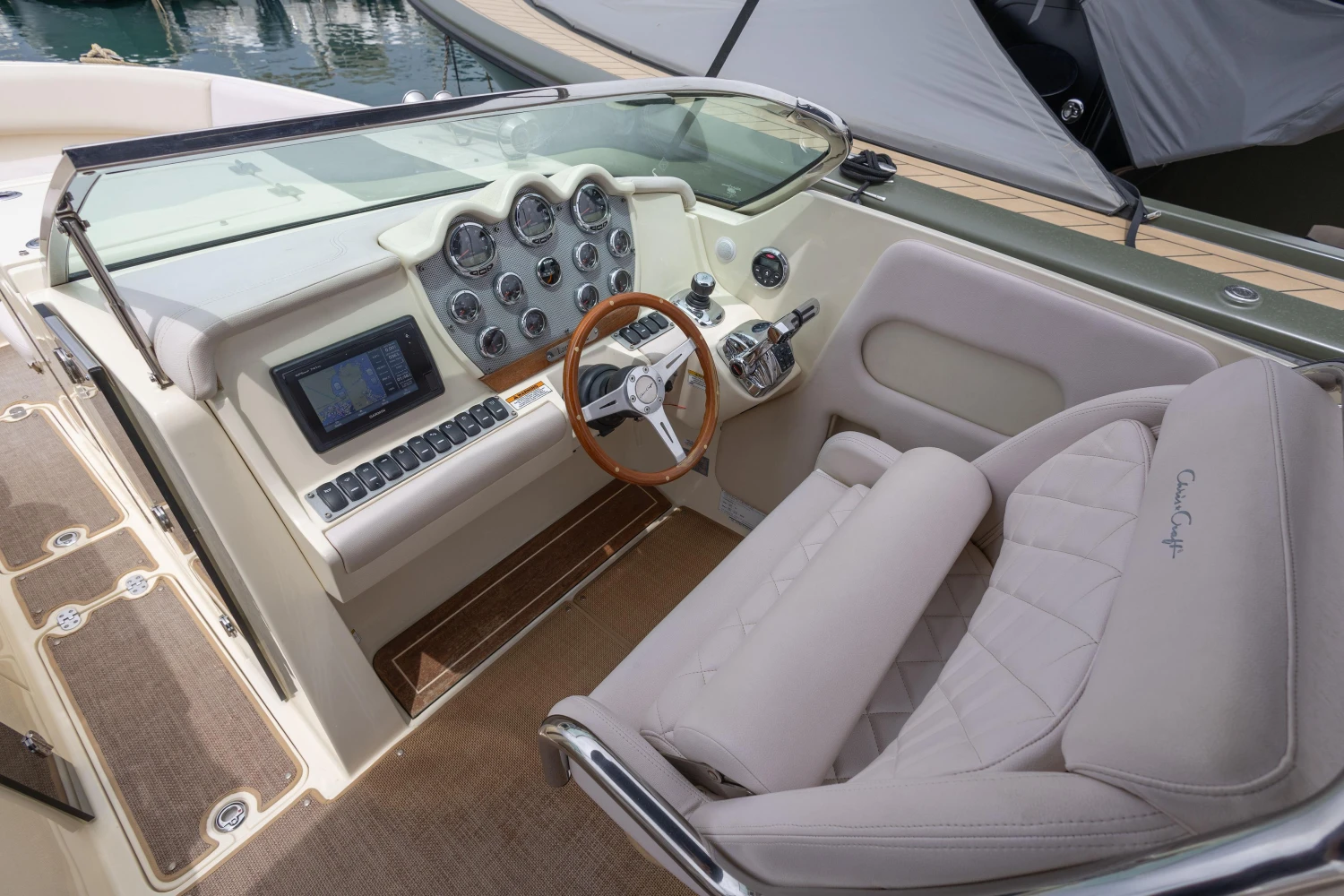 2013 Chris-Craft Launch 32 cockpit with steering wheel, dashboard, and beige seating.