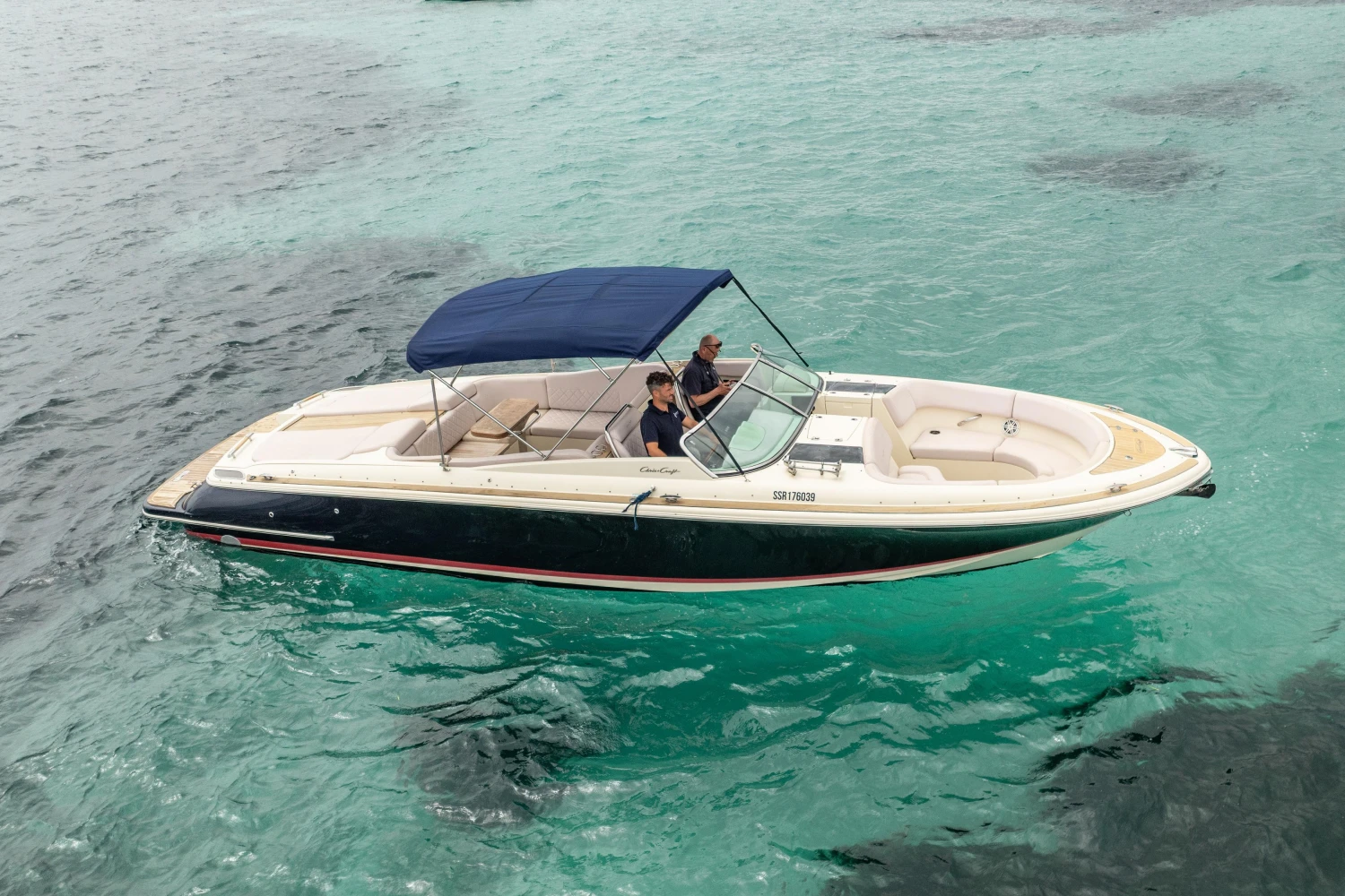 2013 Chris-Craft Launch 32 boat cruising on clear turquoise water.