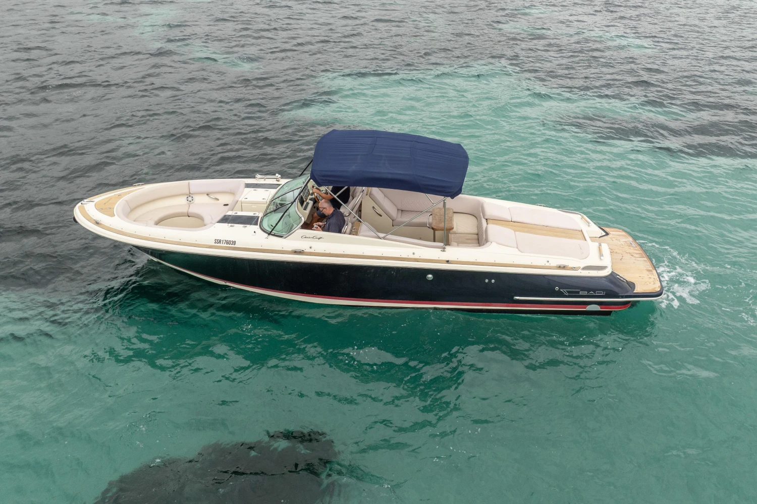 2013 Chris-Craft Launch 32 boat cruising on clear blue water.