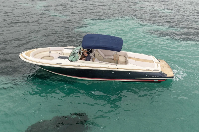 2013 Chris-Craft Launch 32 boat cruising on clear blue water.