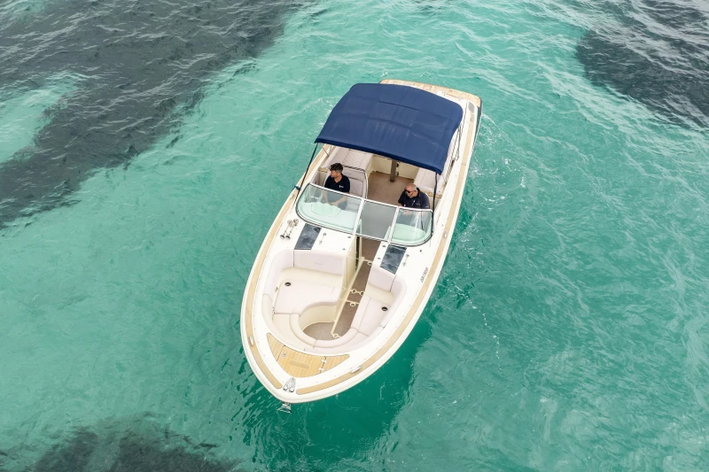 2013 Chris-Craft Launch 32 boat on clear turquoise water, aerial view.