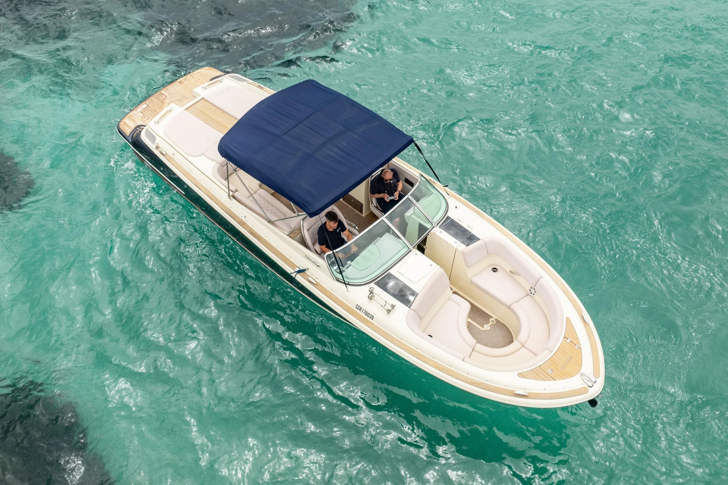 2013 Chris-Craft Launch 32 boat cruising on clear turquoise water.