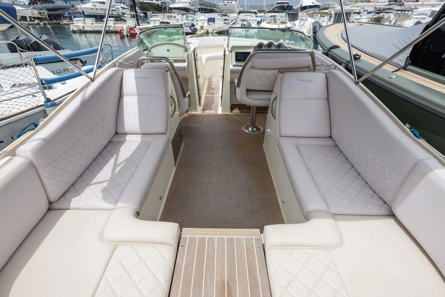 2013 Chris-Craft Launch 32 boat interior with luxurious seating and wood flooring at a marina.