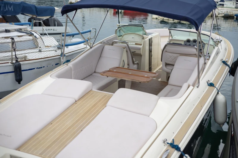 2013 Chris-Craft Launch 32 boat with spacious seating and wooden table, docked at marina.