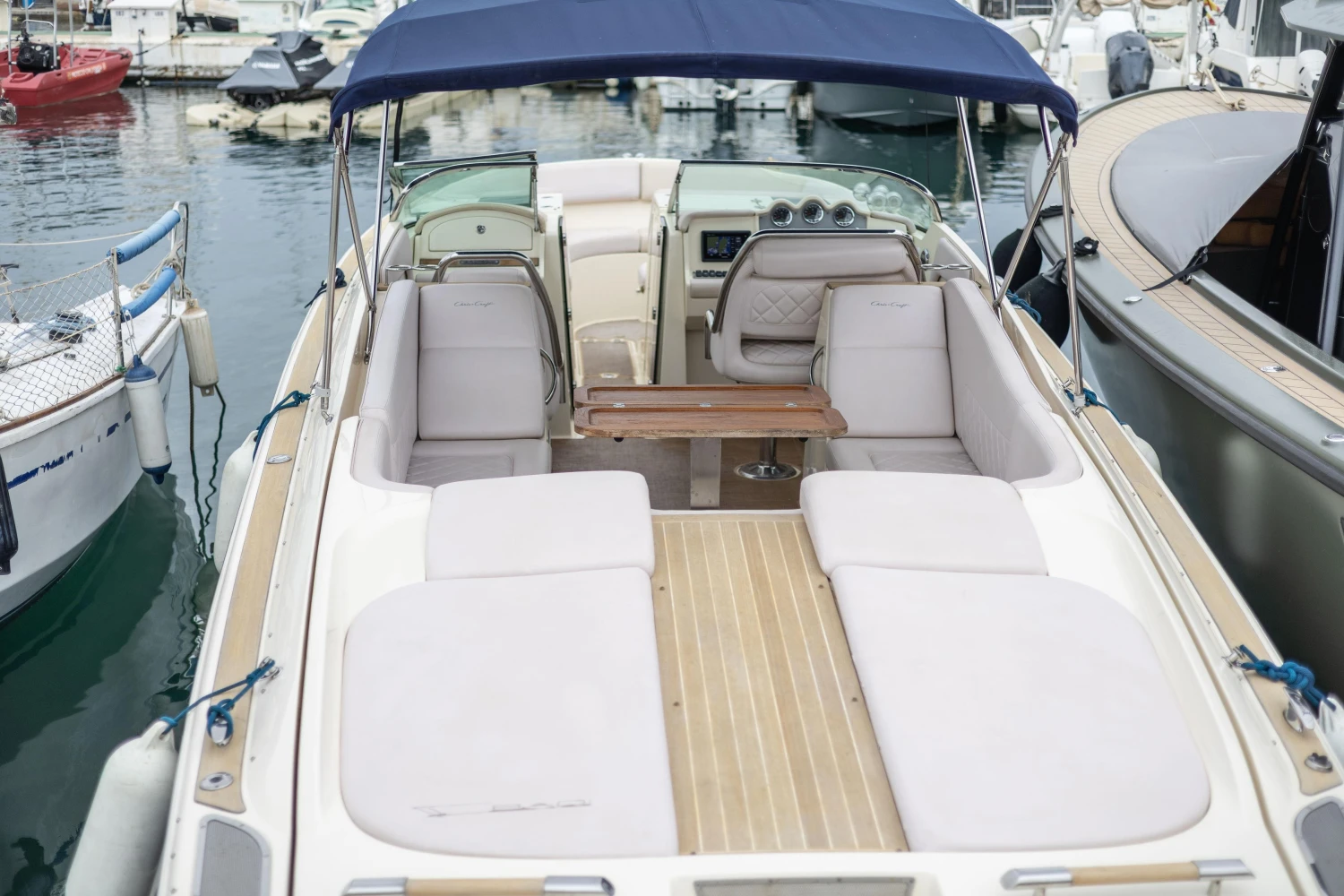 2013 Chris-Craft Launch 32 boat with spacious seating and blue canopy at marina.
