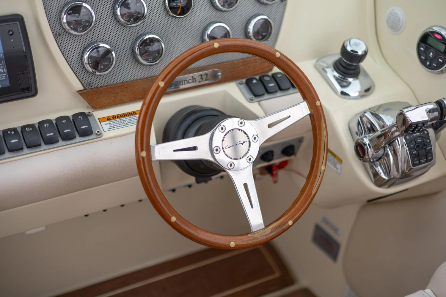2013 Chris-Craft Launch 32 dashboard with wooden steering wheel and control panel.