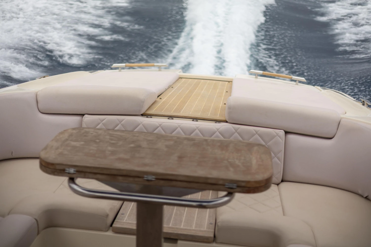 2013 Chris-Craft Launch 32 boat interior with wooden table and cushioned seating.