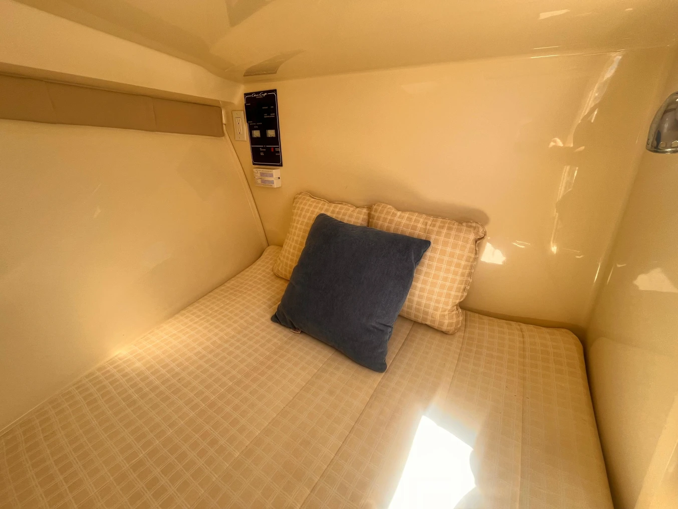 2013 Chris-Craft Launch 32 cabin interior with cozy bed and pillows.