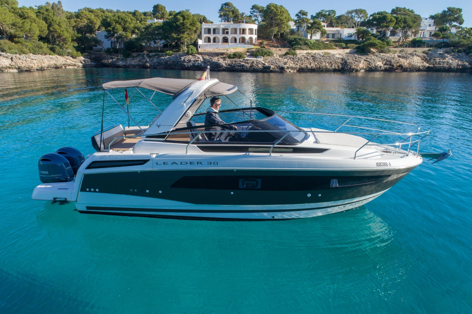 2018 Jeanneau Leader 30 boat on clear blue water, scenic coastal background.
