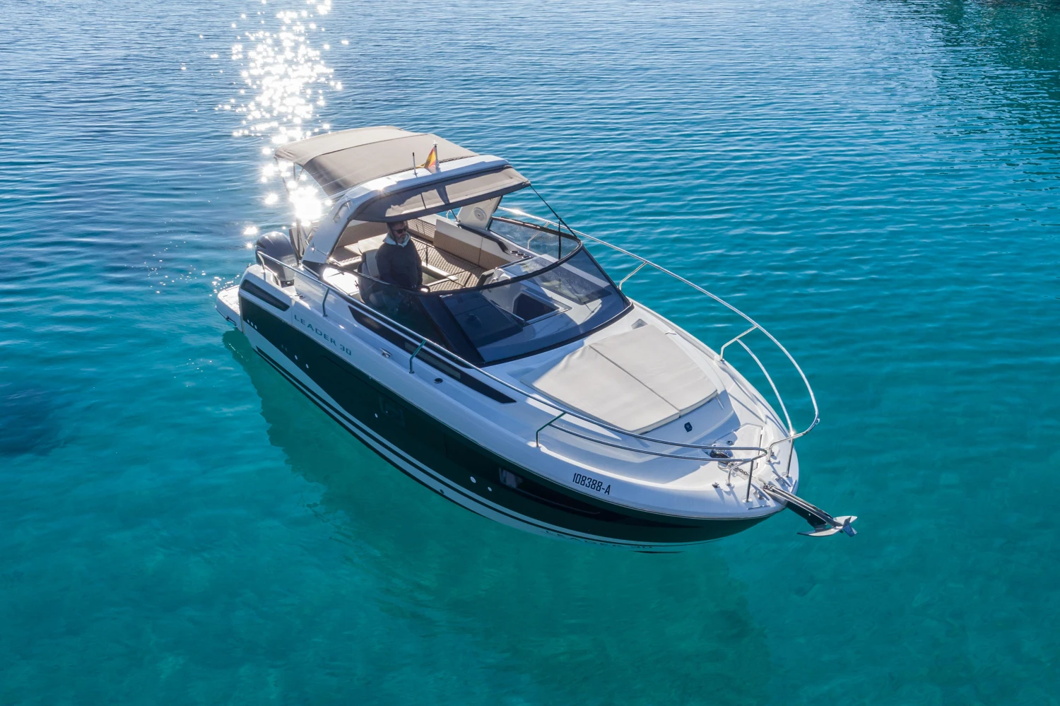 2018 Jeanneau Leader 30 boat on clear blue water, reflecting sunlight.
