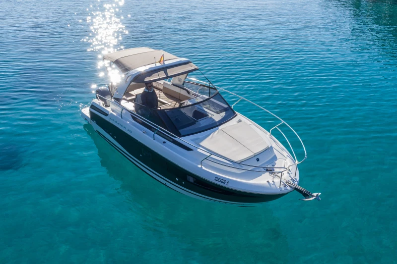 2018 Jeanneau Leader 30 boat on clear blue water, reflecting sunlight.