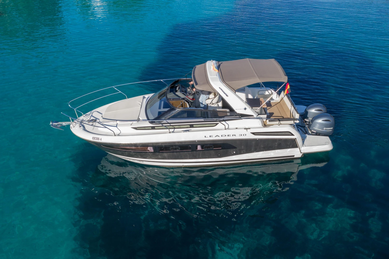 2018 Jeanneau Leader 30 boat on clear blue water, side view.