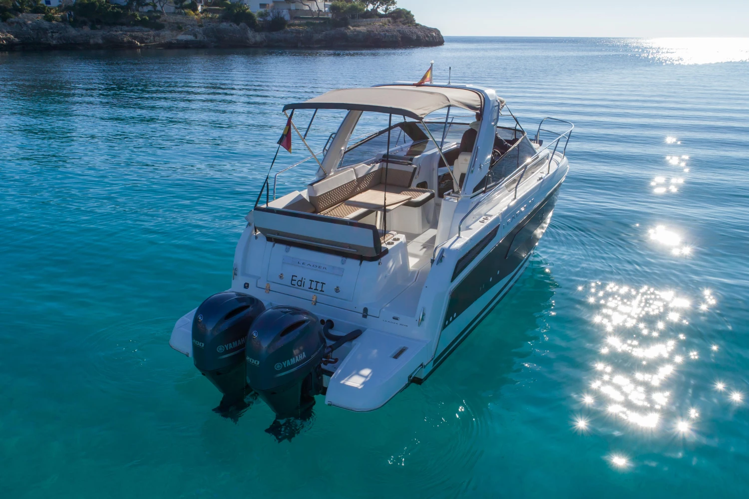 2018 Jeanneau Leader 30 boat on clear blue water, rear view with twin engines.