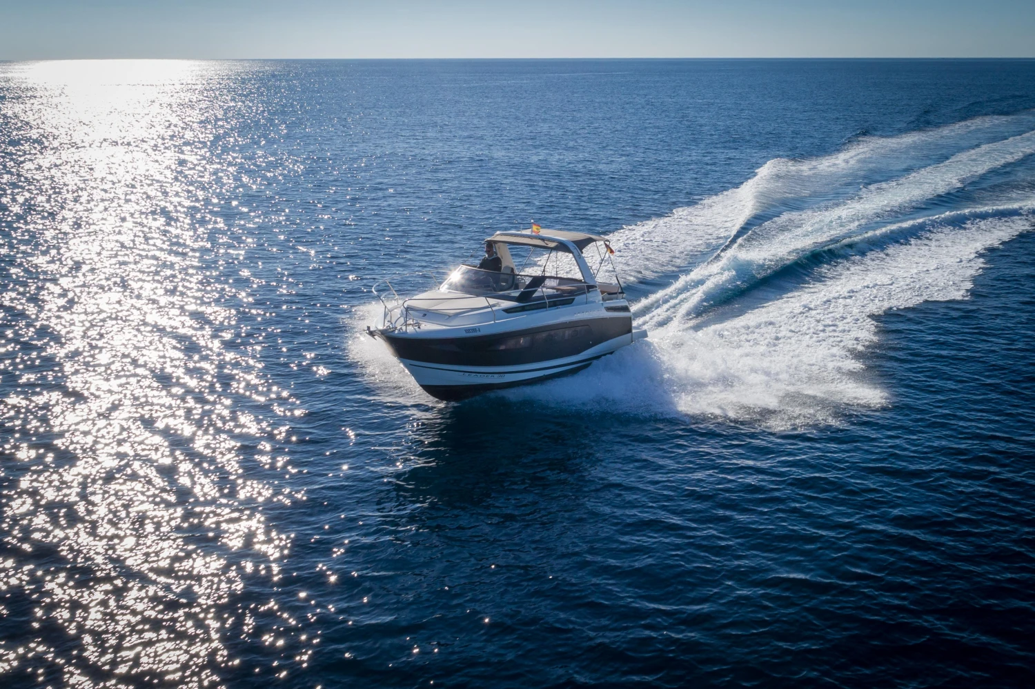 2018 Jeanneau Leader 30 cruising on open sea under clear blue sky.