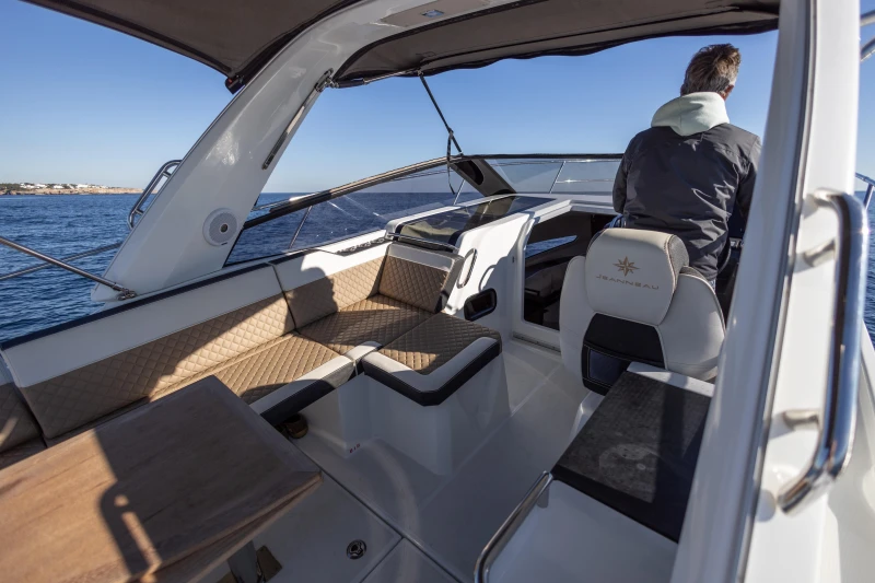 2018 Jeanneau Leader 30 boat interior with seating and helm, cruising on open water.