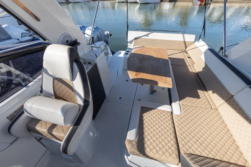 2018 Jeanneau Leader 30 boat interior with cushioned seating and wooden table.