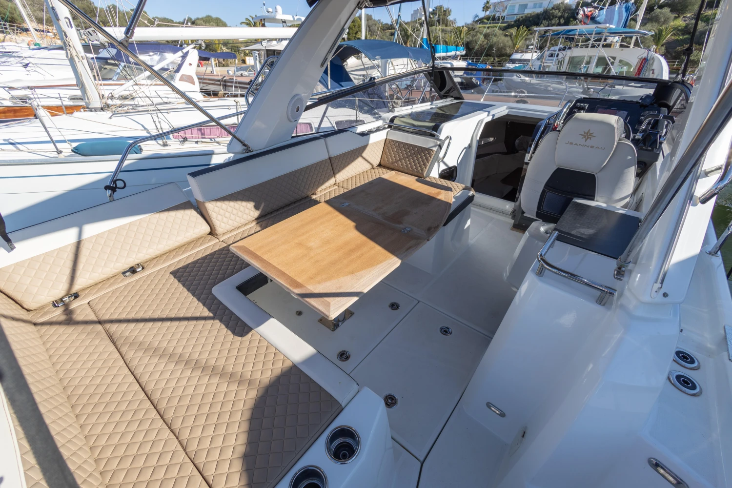 2018 Jeanneau Leader 30 boat interior with seating and table in a marina setting.