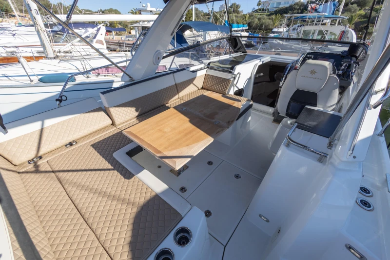2018 Jeanneau Leader 30 boat interior with seating and table in a marina setting.