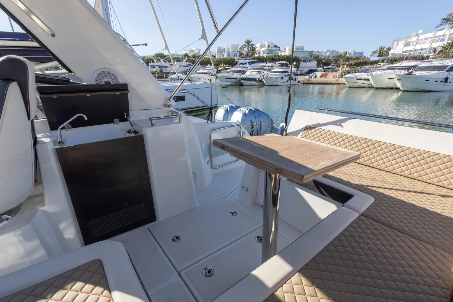 2018 Jeanneau Leader 30 yacht interior with seating and table, docked in a marina.
