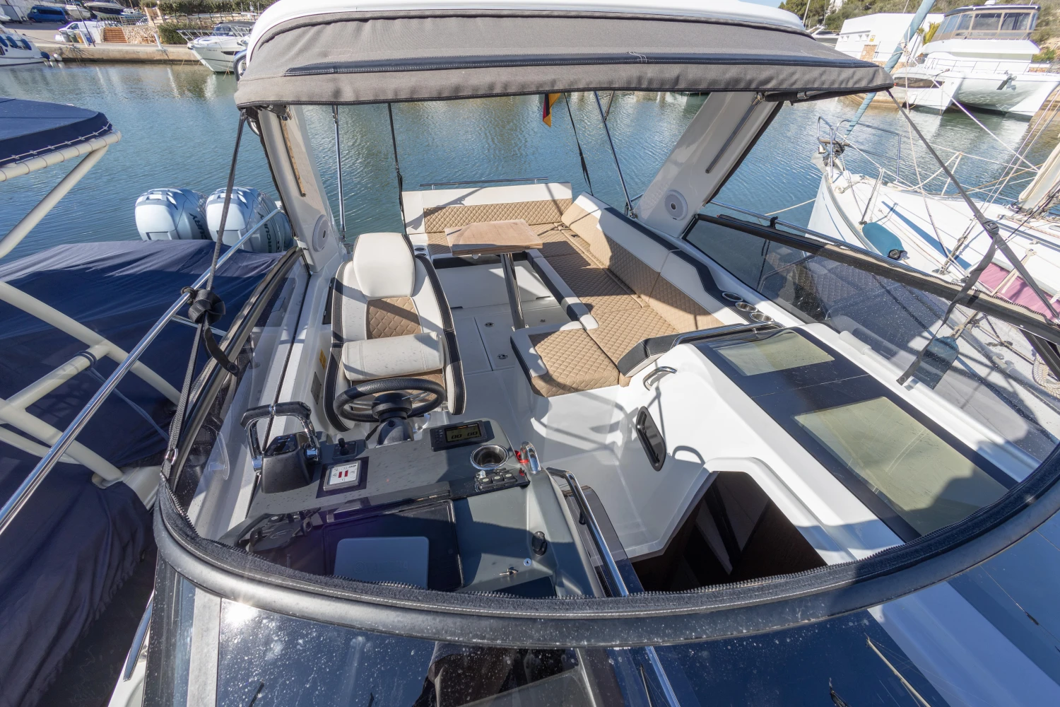 2018 Jeanneau Leader 30 boat interior with seating and controls, docked in a marina.