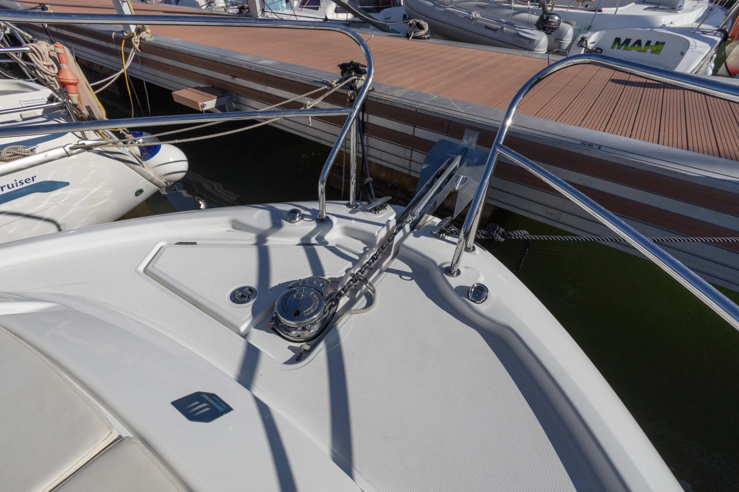 2018 Jeanneau Leader 30 yacht bow with anchor chain at marina dock.