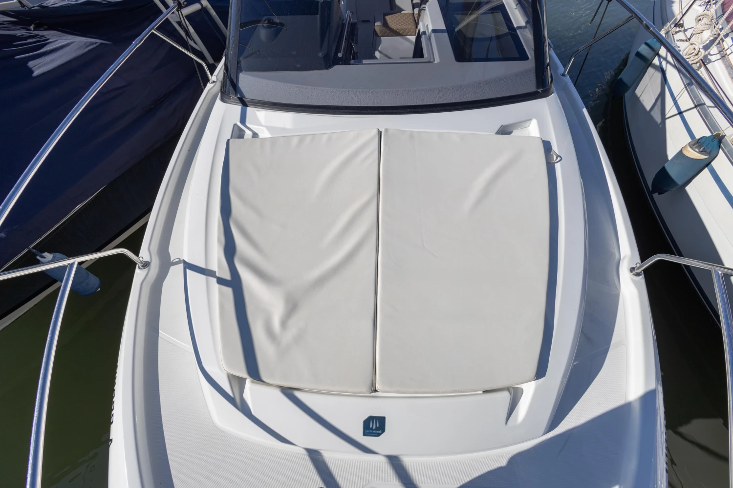 2018 Jeanneau Leader 30 boat with cushioned deck, docked in marina.