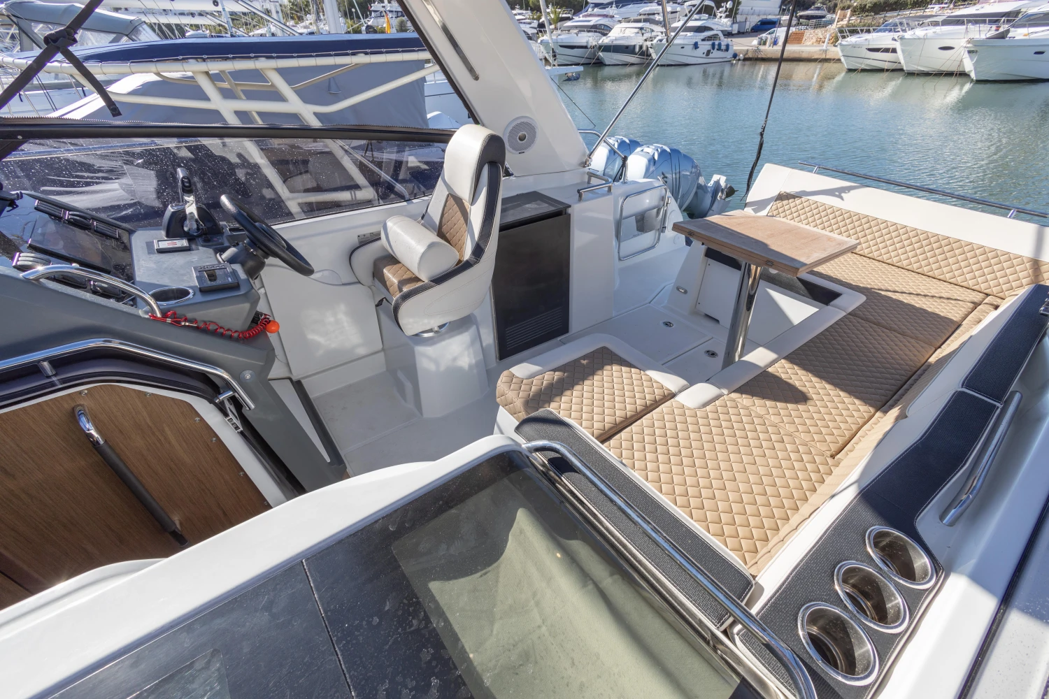 2018 Jeanneau Leader 30 yacht interior with seating and helm, docked at marina.