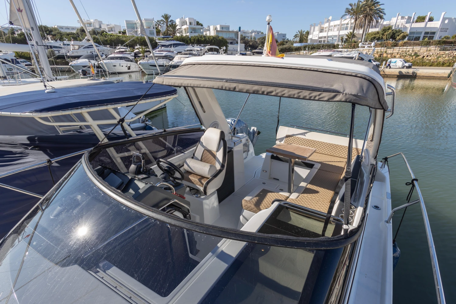 2018 Jeanneau Leader 30 boat docked in a marina, featuring a spacious cockpit and modern design.