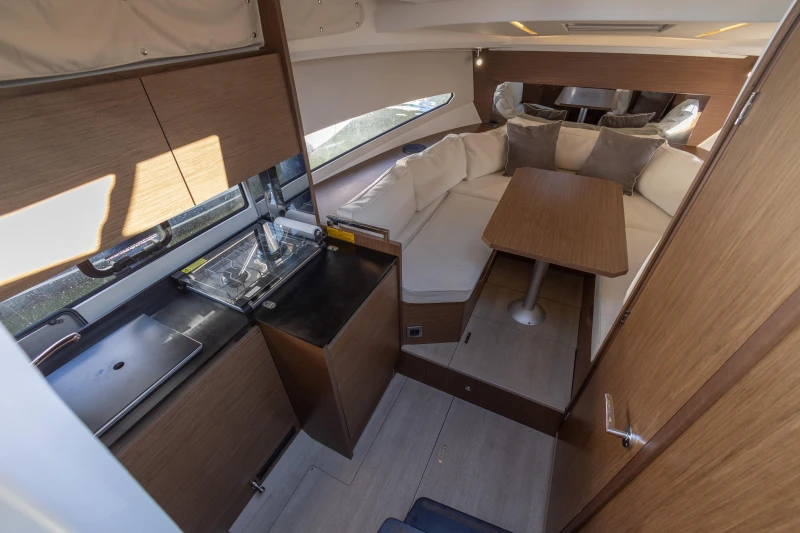 Interior of 2018 Jeanneau Leader 30 yacht with modern kitchen and cozy seating area.