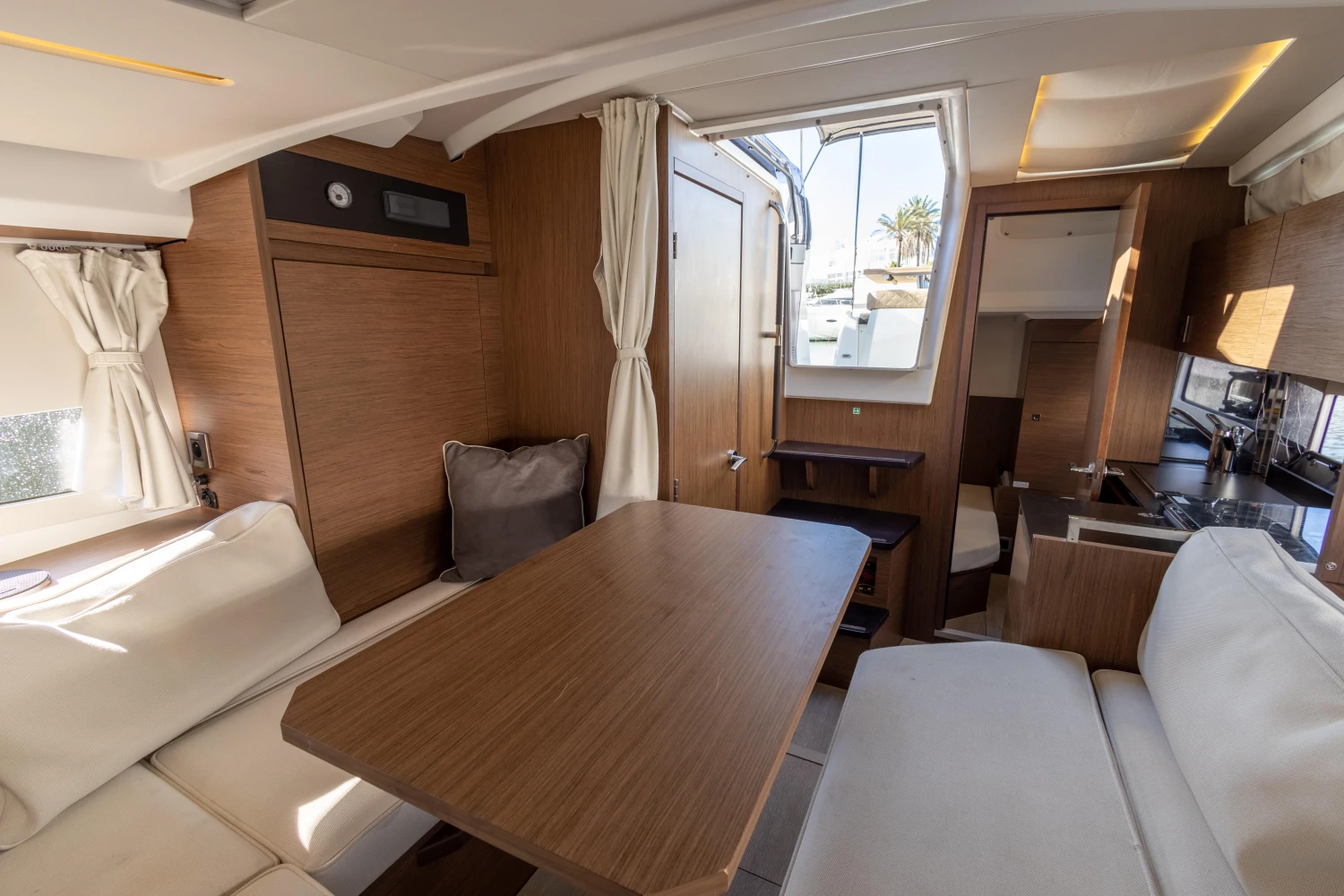 Interior of 2018 Jeanneau Leader 30 yacht with wooden table and seating area.