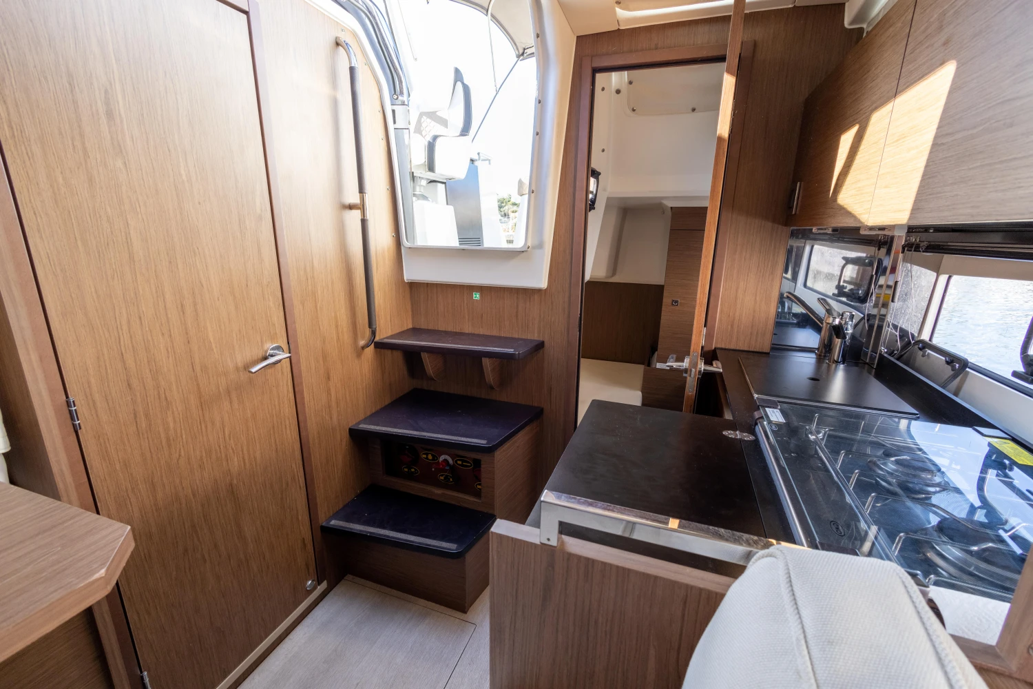 Interior of 2018 Jeanneau Leader 30 yacht with modern wood finish and compact kitchen.