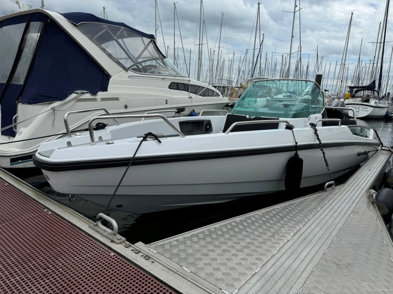 2023 Nordkapp Enduro 705 boat docked at marina with sailboats in background.