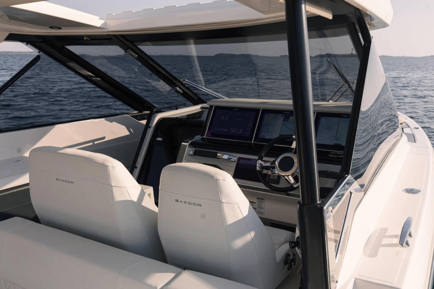 2025 Saxdor 400 GTO boat interior with modern dashboard and steering, on open water.
