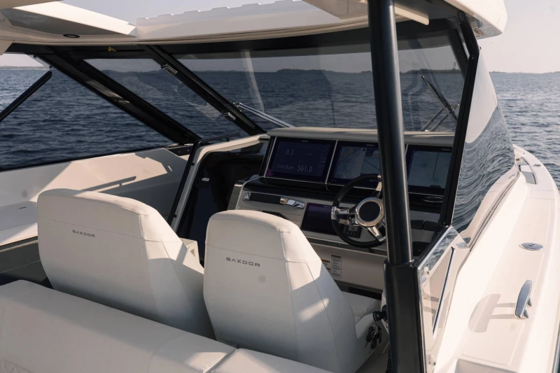 2025 Saxdor 400 GTO boat interior with modern dashboard and steering, on open water.