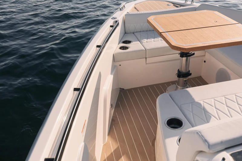2025 Saxdor 400 GTO boat interior with elegant seating and wooden table on calm water.