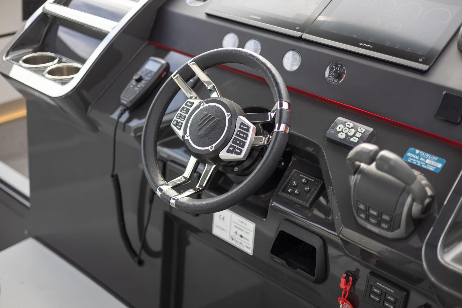 Steering wheel and controls of 2023 Fairline F//Line 33 yacht cockpit.