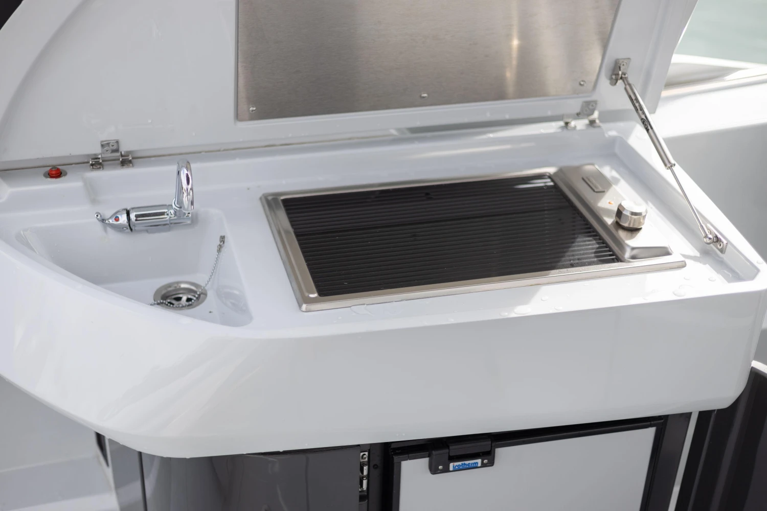 Outdoor kitchenette on 2023 Fairline F//Line 33 yacht with sink and grill.