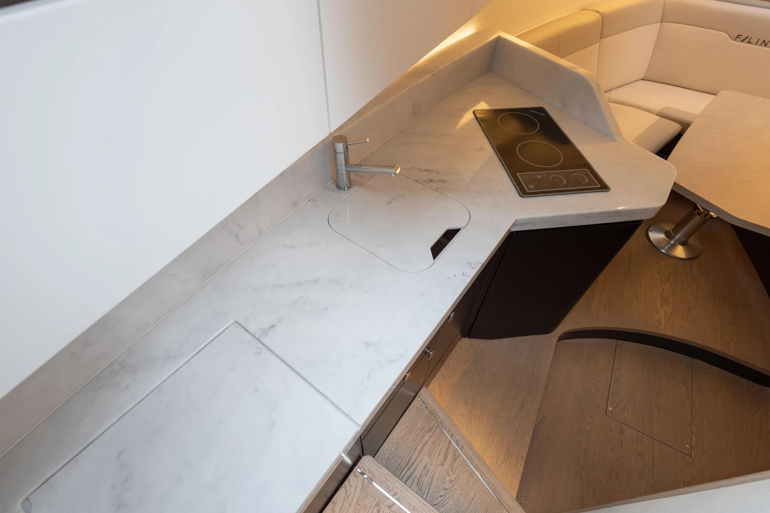 Modern kitchen area in 2023 Fairline F//Line 33 yacht with sleek countertops and seating.