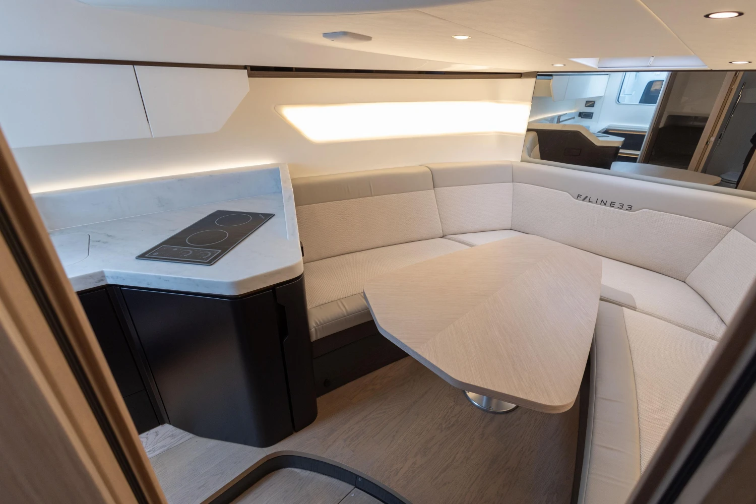 Luxurious interior of 2023 Fairline F//Line 33 yacht with modern seating and kitchenette.