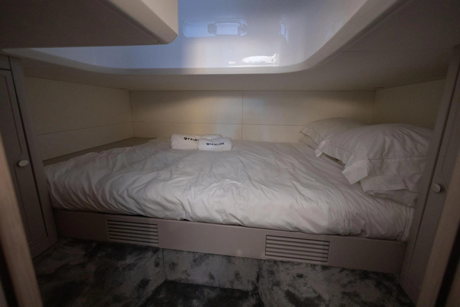 2023 Fairline F//Line 33 cabin interior with cozy bed and white linens.