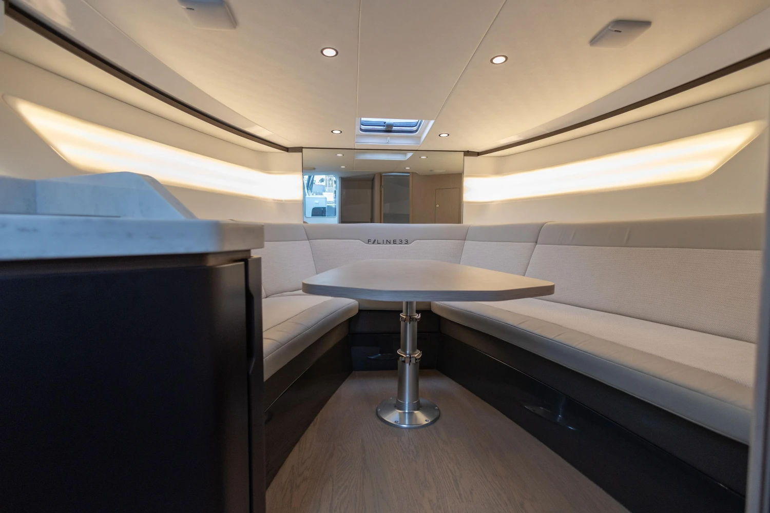Luxurious interior of 2023 Fairline F//Line 33 yacht with elegant seating and table.