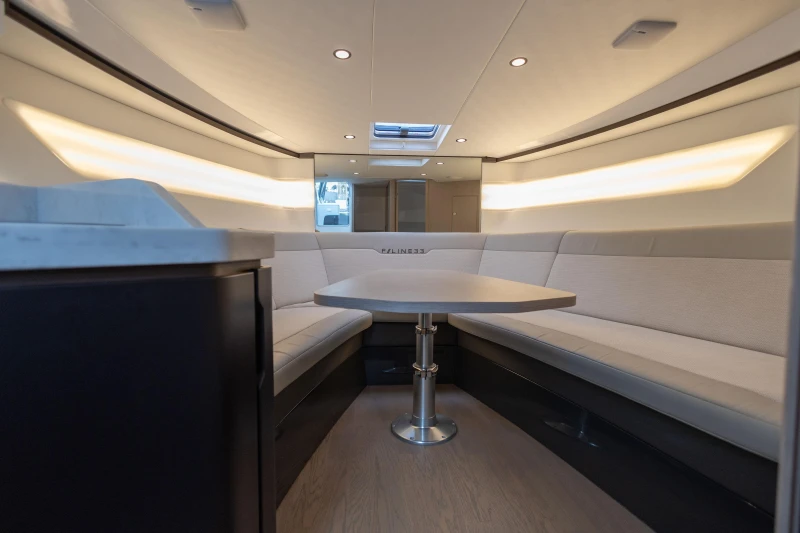 Luxurious interior of 2023 Fairline F//Line 33 yacht with elegant seating and table.